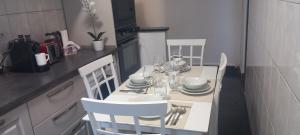 einen weißen Tisch und Stühle in einer Küche mit einem Tisch und einem Chairsktop in der Unterkunft Apartament Brasov in Braşov