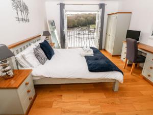 a bedroom with a bed with a teddy bear on it at Egret in Milford Haven