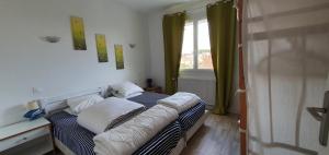 a bedroom with a bed with a couch and a window at Maison bleu océan in Saint-Palais-sur-Mer