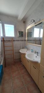 ein Badezimmer mit 2 Waschbecken und einem Spiegel in der Unterkunft Maison bleu océan in Saint-Palais-sur-Mer