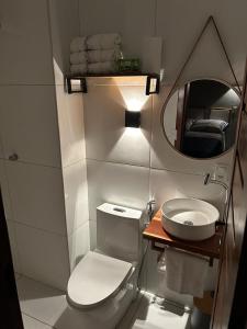 a small bathroom with a toilet and a mirror at Essência de Atins in Atins