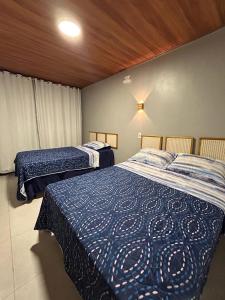 1 Schlafzimmer mit 2 Betten und blauen Bettdecken in der Unterkunft Essência de Atins in Atins