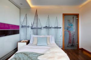 a bedroom with a large bed with sailboats on the wall at Elite Apartments Seaview Tower in Gdańsk