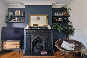 a living room with a black fireplace and a mirror at Lovely 3 bedroom Whitley Bay Townhouse. in Whitley Bay