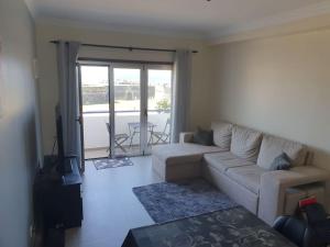 ein Wohnzimmer mit Couch und Tisch und ein Balkon in der Unterkunft Appartement de 90 m2 en 1ere ligne face a l'ocean in Vila Praia de Âncora