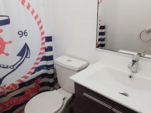 ein Badezimmer mit einem weißen WC und einem Waschbecken in der Unterkunft Departamento Mar, Bosque, Lomas de Papudo III, wifi in Papudo