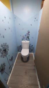 a bathroom with a toilet with flowers on the wall at "PONY POD" at Nelson Park Riding Centre Ltd - GLAMPING POD also available the fox pod and Trailor Escapes- BIRCHINGTON, RAMSGATE, BROADSTAIRS MARGATE in Kent