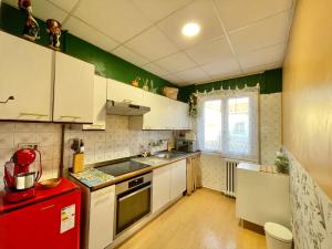 cocina con armarios blancos y nevera roja en Casa Rural, en Valtierra