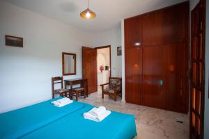 1 dormitorio con cama azul y armario de madera en SINI Apartments 3A, en Kefalos