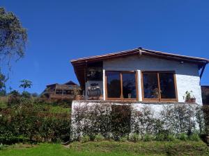 una pequeña casa sentada en la cima de un campo en alto palmas 2.0 en Medellín