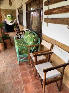 un grupo de sillas y mesas en un patio en Acogedora cabaña con bella vista a las montañas de Villa de Leyva, en Santa Sofía