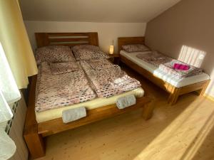 two twin beds in a room with wooden floors at Nad Strumykiem APARTAMENT in Ochotnica Dolna