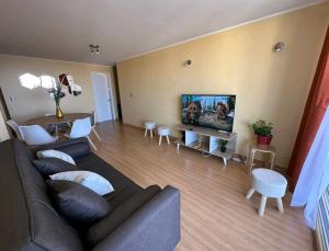a living room with a couch and a flat screen tv at Departamento con vista al mar in Viña del Mar