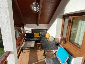 a balcony with a couch and a table and chairs at Nad Strumykiem APARTAMENT in Ochotnica Dolna