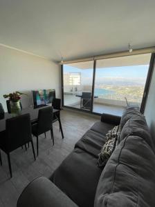 sala de estar con sofá y mesa con vistas en departamento con vista al mar, en Concón
