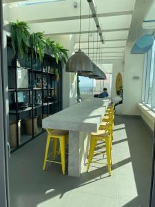una cocina con una mesa larga y sillas amarillas en departamento con vista al mar, en Concón