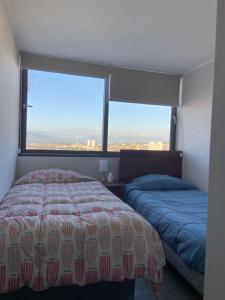 1 dormitorio con 2 camas y ventana grande en departamento con vista al mar, en Concón