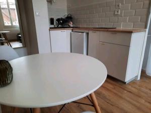 a kitchen with a white table and a white counter top at Le Black and White cosy studio Toulouse centre in Toulouse