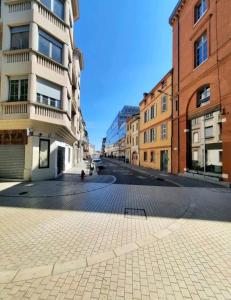 an empty street in a city with buildings at Le Black and White cosy studio Toulouse centre in Toulouse