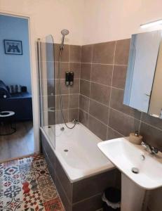 a bathroom with a shower and a tub and a sink at Le Black and White cosy studio Toulouse centre in Toulouse