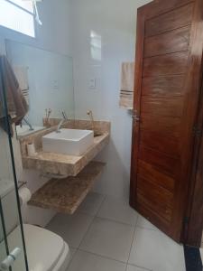 uma casa de banho com um lavatório e um WC em Casa da Mari em Vera Cruz de Itaparica