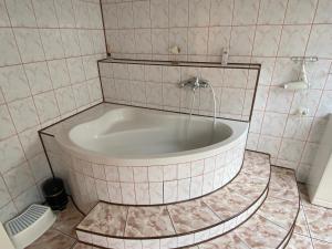 a bath tub in a tiled bathroom with a sink at Nad Strumykiem APARTAMENT in Ochotnica Dolna +51 photos