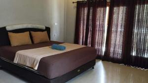a bedroom with a bed with a blue object on it at Bungalow Pandan Dure in Selong