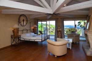 - une chambre avec un lit et une horloge murale dans l'établissement Villa Darius Belle et grande villa, piscine, clim, vue mer Cavalaire sur Mer, à Cavalaire-sur-Mer