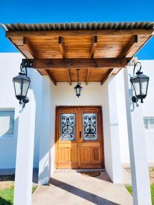 a front door of a house with two lights at Puesta de Sol Casa Quinta in Azul