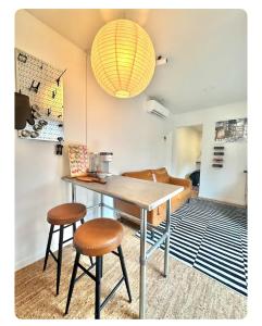 a table and two stools in a room at Nomehaus shipping container studio residential neighborhood ATHENS in Athens