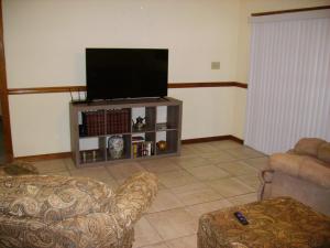 a living room with two chairs and a flat screen tv at Oakhaven in Long Beach