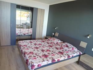 a bedroom with a bed with a floral bedspread at Apartment D&J 2 in Mošćenička Draga