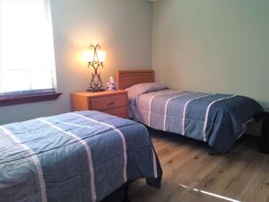 a bedroom with two beds and a table with a lamp at Oakhaven in Long Beach