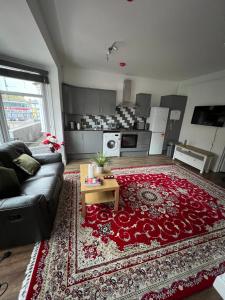 ein Wohnzimmer mit einem Sofa und einem roten Teppich in der Unterkunft Silk Accommodation in Margate