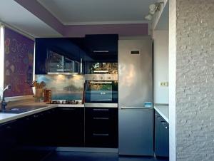 a kitchen with stainless steel appliances and purple walls at Apartment D&J 2 in Mošćenička Draga