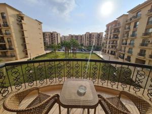 balkon ze stołem i krzesłami na balkonie w obiekcie El Rehab, 3 BR Apt Garden view Sweet Homies w mieście New cairo