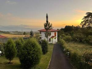 une petite maison avec une croix au-dessus dans l'établissement Parque Nacional Volcán Poás Cabaña Abby, à Bajos Tigre