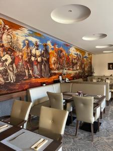 a restaurant with a large painting on the wall at Hotel Wagner in Szombathely