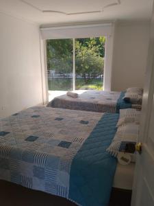 2 Betten in einem Zimmer mit Fenster in der Unterkunft Hotel parador tropical in Cartagena de Indias