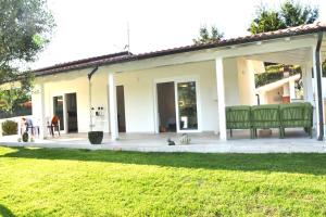 a patio with two green benches and a yard at Villa Costa Medea in Camaiore
