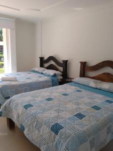 1 Schlafzimmer mit 2 Betten und einem Fenster in der Unterkunft Hotel parador tropical in Cartagena de Indias