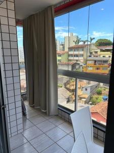 een kamer met 2 witte stoelen en een groot raam bij Apartamento de 3 quartos na Praia da Fonte Guarapari in Guarapari