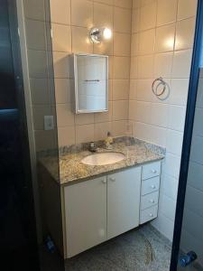 a bathroom with a sink and a mirror at Apartamento de 3 quartos na Praia da Fonte Guarapari in Guarapari