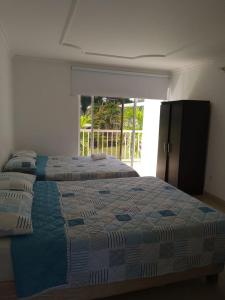 1 Schlafzimmer mit 2 Betten und einem großen Fenster in der Unterkunft Hotel parador tropical in Cartagena de Indias