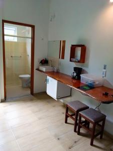 a bathroom with a counter and a sink and a toilet at Green Lodge Eco Life Hotel in Florianópolis