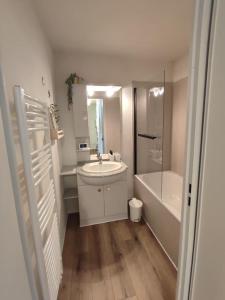 biała łazienka z umywalką i prysznicem w obiekcie Cocon Montagnard avec Terrasse et vue Panoramique w mieście Germ