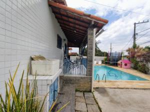 une maison avec une piscine et un auvent dans l'établissement Casa Alto da Boa Vista - 3 quartos, à Araruama