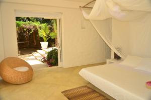 a bedroom with a bed and a door to a patio at Villa Los Cocos Baru in Barú