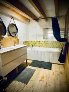 a bathroom with a sink and a bath tub at Le 1830 in Églisolles