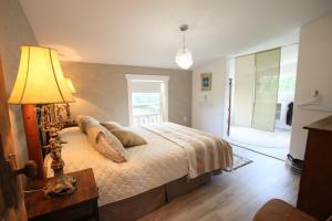 a bedroom with a bed and a lamp on a table at Oyster Shell Cottage in York